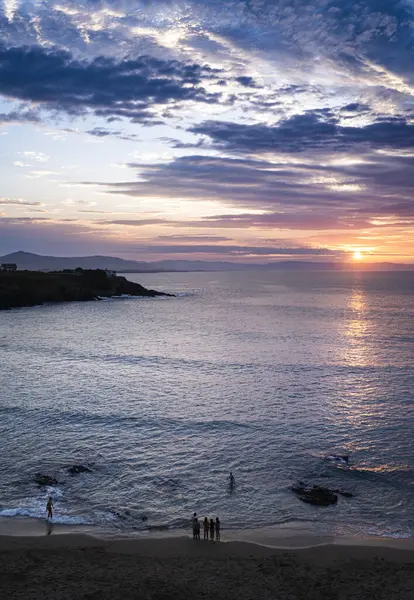 海の上の夕日とビーチで認識できない人々の垂直な形式の風景 エアリアルビュー — ストック写真