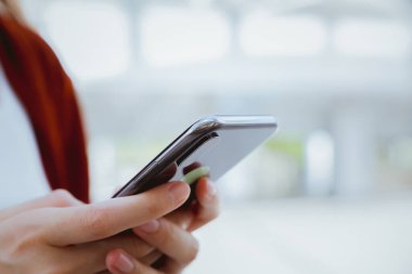 Şehir merkezinde yürürken elinde akıllı telefon tutan bir kadın. Telefonu kullanma konsepti günlük hayatta gereklidir..