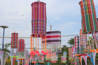 An ancient merit-making tradition using artifacts and decorative flags according to the religious beliefs of communities in the Northeast of Thailand.