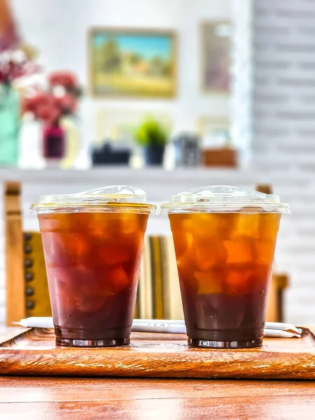 Kahve için kapağı olan iki plastik kahve fincanı masaya konur. Arka planda metin için boşluk var.