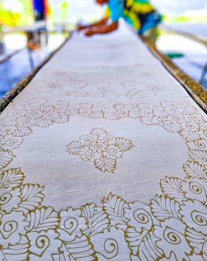 Tayland 'da kumaşa el yazması desenler çizerek batik yapmak.