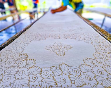 Tayland 'da kumaşa el yazması desenler çizerek batik yapmak.