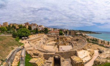 Yazın Playa El Milagro plajındaki antik Roma amfitiyatrosu ve Tarragona şehir manzarası, Tarragona, İspanya