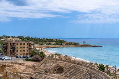 Akdeniz 'deki antik Roma amfitiyatrosunun enkazının havadan görünüşü, yaz aylarında Playa El Milagro plajı, Tarragona, Katalonya, İspanya' nın yanında yer alıyor.