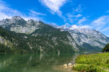 Berchstegaden Ulusal Parkı 'ndaki Watzmann ve Bavyera dağlarının zirvesinde güneşli bir yaz gününde mavi gökyüzü ve bulutlu Konigssee Gölü manzarası, Schoenau, Bavyera, Almanya