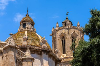 Yazın güneşli bir günde Tarragona, Katalonya, İspanya 'da renkli çatı ve saat kulesi olan Tarragona katedralinin yakın görüntüsü