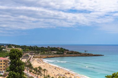 Balearic Akdeniz ve Playa El Milagro 'nun (Platja del Miracle) yaz mevsiminde Tarragona, Katalonya, İspanya' da tren istasyonu yakınlarındaki manzaralı sahili çok güzel bir manzara.