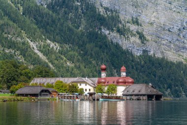 Konigssee Gölü 'nün göl kıyısındaki St. Bartholomae hac kilisesinin güzel manzarası. Berchstegaden Milli Parkı' nın arka planında güneşli bir yaz günü, Schoenau, Bavyera, Almanya
