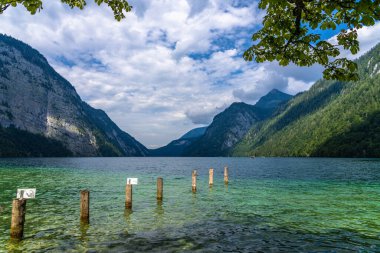 Güneşli bir yaz gününde Berchtesgaden Ulusal Parkı 'nda arka planda Bavyera Alpleri' nin bulunduğu Konigssee Gölü 'nün güzel manzarası mavi gökyüzü ve bulutlu, Schoenau, Bavyera, Almanya