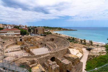 Akdeniz 'deki antik Roma amfitiyatrosunun enkazının havadan görünüşü, yaz aylarında Playa El Milagro plajı, Tarragona, Katalonya, İspanya' nın yanında yer alıyor.