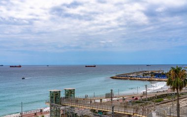 Balearic Akdeniz ve Playa El Milagro 'nun (Platja del Miracle) yaz mevsiminde Tarragona, Katalonya, İspanya' da tren istasyonu manzaralı sahili manzarası