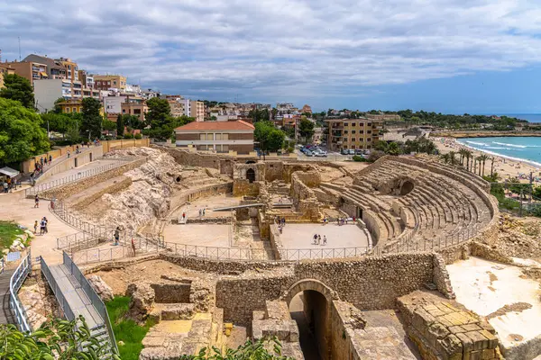 Yazın Playa El Milagro plajı, Tarragona, Katalonya, İspanya yakınlarındaki Akdeniz kıyısındaki antik Roma amfitiyatrosu ve Tarragona şehir manzarasının güzel manzarası