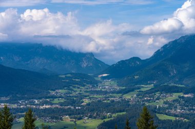 Berchtesgadener 'da Koenigssee Gölü' nün göl kıyısındaki Schoenau şehrinin hava manzarası güneşli bir yaz gününde Jenner Dağı 'nın ortasından Almanya' nın mavi gökyüzü ve bulutlu Bavyera 'ya uzanır.
