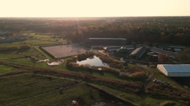 Bir grup safkan at ahırın yanındaki otlakta yürüyor. Uzun bir akşam gölgesi. Çiftlikte ya da çiftlikte güzel hayvanlar. İHA 'dan hava üstü görüntüsü