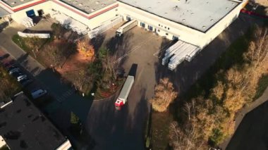 Depo rampalarında durmakta olan kargo römorklu bir tırın hava görüntüsü. Yükleme merkezli büyük lojistik parkındaki malları yüklemek / boşaltmak için.