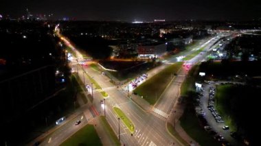 Gece şehir yollarının tepesinde hava manzaralı arabalar var. Geceleri modern gökdelenleri olan şehir manzarası. Görkemli şehir manzarası trafik otobanlı neon fenerlerle aydınlatılıyor. Sinematik araç manzarası