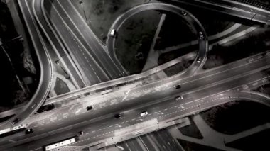 Varşova 'nın banliyölerinde Polonya' nın kırsal kesimlerinde geceleri yoğun bir otoyol boyunca giden uzun mesafeli yarı karavanların insansız hava aracı görüntüleri. Geceleri otobanın havadan görüntüsü, köprüleri olan arabalar ve kamyonlar yolda.