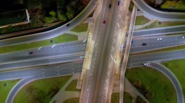 Salgın sonrası Varşova Avrupa 'daki otobanı ve kavşağı gösteren hava gece görüşü. Sokakta kaybolan trafiğin olduğu şehir manzaraları. Yollar ve şeritler kesişiyor