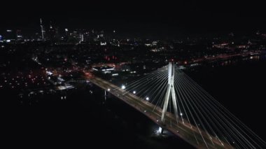 4K kentsel manzarası, gelişmiş yenilik, finansal teknoloji Varşova 'da Varşova ile aydınlatılmış asma köprü üzerinde gece araba trafiği manzarası. Polonya