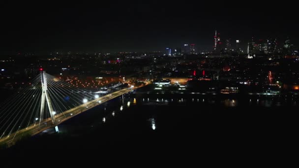 K都市の街並み 先進的な技術革新 金融技術ワルシャワでワルシャワとライトアップされた吊り橋で夜の車のトラフィックの風景航空写真 ポーランド — ストック動画