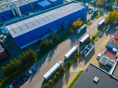 Malzeme deposunun havadan görüntüsü. Sanayi bölgesindeki lojistik merkezi yukarıdan. Lojistik merkezde yüklenen kamyonların hava görüntüsü