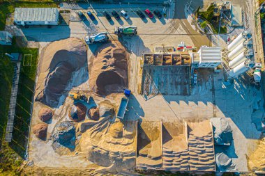 Kamyon ve bahşiş verenler açık çukur kumu madenciliğine park etmiş. İnşaat alanındaki farklı damperli kamyonların hava görüntüsü