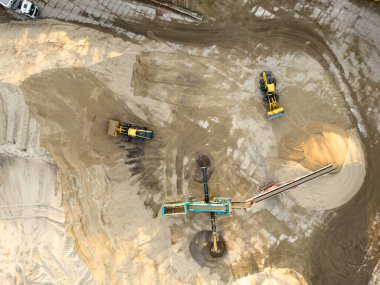 Kazıcı kum madenindeki bir kamyona kum yüklüyor. İnşaat endüstrisi için endüstriyel kum çıkarılıyor.