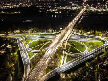 Hava görüntüsü kavşağı kavşağı çevre yolu ve otoyol otoyolları ve hareket halindeki farlı araçlar gece hava manzaralı Varşova 'da şehrin arka planını aydınlatan araçlar.