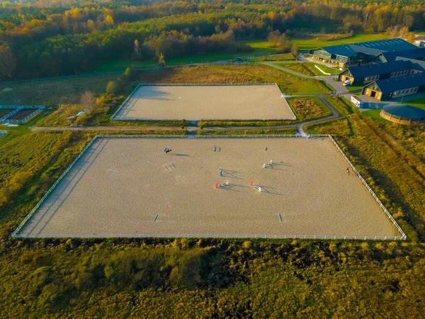 stock image Aerial view of horse rider and horse on training ground at sunset.