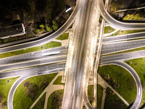 Hava görüntüsü kavşağı kavşağı çevre yolu ve otoyol otoyolları ve hareket halindeki farlı araçlar gece hava manzaralı Varşova 'da şehrin arka planını aydınlatan araçlar.