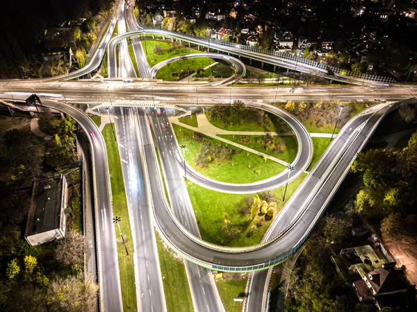 环路和高速公路高速公路高速路和行驶中的前灯汽车交通 夜间空中俯瞰城市背景 — 图库照片