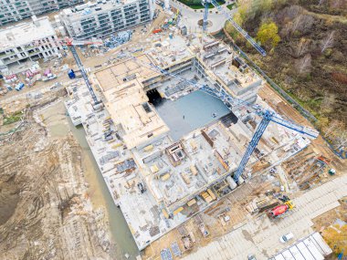 Vinçli ve binalı inşaat alanının havadan görüntüsü. Büyük inşaat ve mimarinin en üst görünümü.