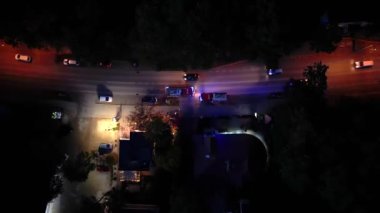 Bir itfaiyecinin kornaya basması ve trafikte koşturması. İtfaiye araçları gece yol ayrımından geçiyor. İtfaiye ekipleri. Havadan