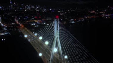 Varşova şehir manzarasının panoramik görüntüsü. Swietokrzyski asma köprüsü Vistula nehri üzerinde, gökdelenler şehir merkezinde geceleri gökdelenler. Sinema şehri panorama üstgeçit kablo köprüsü kuleleri