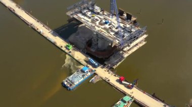 Nehir üzerinde yeni bir köprü inşa ediliyor. Köprüden geçen kule vinçleri. Kazıcılar ve yükleyiciler köprüler ve yollar üzerinde çalışıyor. Varşova. Polonya