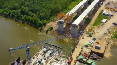Nehir üzerinde yeni bir köprü inşa ediliyor. Köprüden geçen kule vinçleri. Kazıcılar ve yükleyiciler köprüler ve yollar üzerinde çalışıyor. Varşova. Polonya