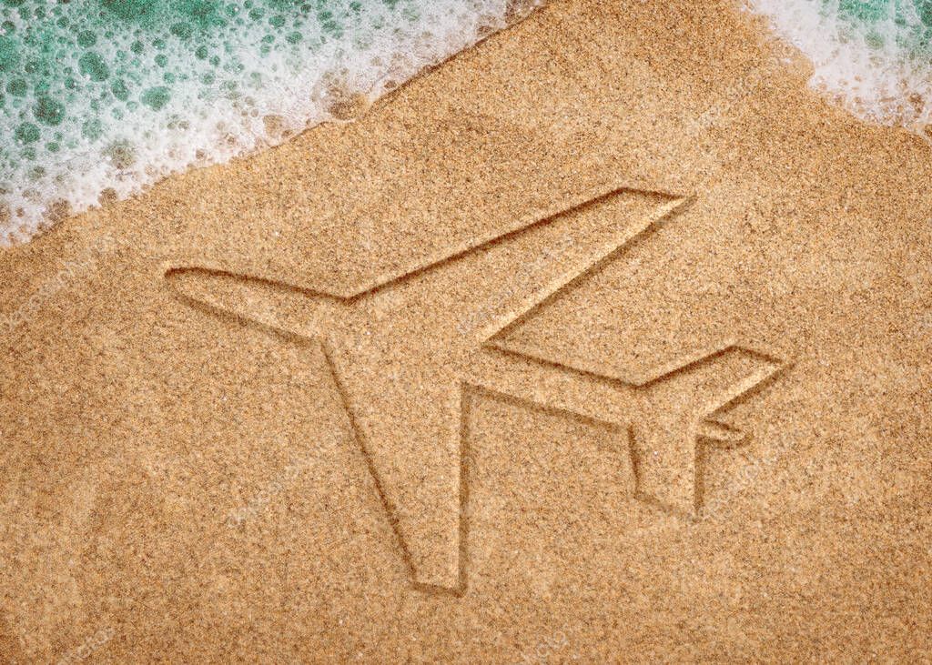 sandy beach with drawing of a Plane in the sand or symbol.
