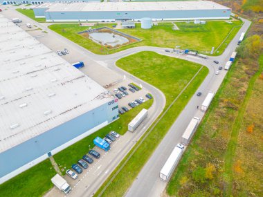 Malzeme deposunun havadan görüntüsü. Sanayi bölgesindeki lojistik merkezi yukarıdan. Lojistik merkezde yüklenen kamyonların hava görüntüsü