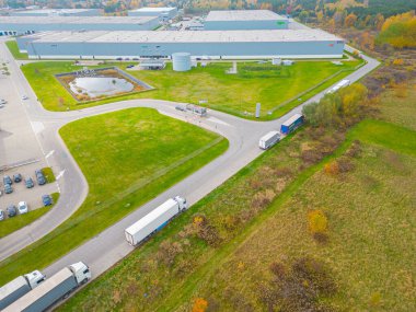 Malzeme deposunun havadan görüntüsü. Sanayi bölgesindeki lojistik merkezi yukarıdan. Lojistik merkezde yüklenen kamyonların hava görüntüsü