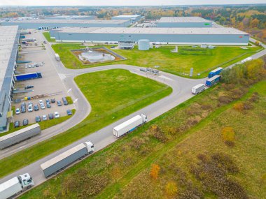 Malzeme deposunun havadan görüntüsü. Sanayi bölgesindeki lojistik merkezi yukarıdan. Lojistik merkezde yüklenen kamyonların hava görüntüsü