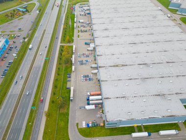 Malzeme deposunun havadan görüntüsü. Sanayi bölgesindeki lojistik merkezi yukarıdan. Lojistik merkezde yüklenen kamyonların hava görüntüsü