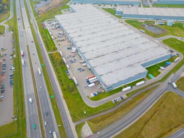 Malzeme deposunun havadan görüntüsü. Sanayi bölgesindeki lojistik merkezi yukarıdan. Lojistik merkezde yüklenen kamyonların hava görüntüsü