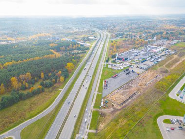 Gün batımında yükleme / boşaltma malları için rampalarda bekleyen bir lojistik parkı, merkez ve kargo karavanıyla dolu bir sürü tırın hava görüntüsü..