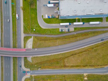 Gün batımında yükleme / boşaltma malları için rampalarda bekleyen bir lojistik parkı, merkez ve kargo karavanıyla dolu bir sürü tırın hava görüntüsü..