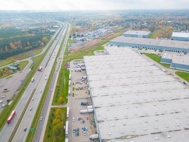 Gün batımında yükleme / boşaltma malları için rampalarda bekleyen bir lojistik parkı, merkez ve kargo karavanıyla dolu bir sürü tırın hava görüntüsü..