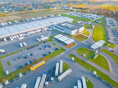 Malzeme deposunun havadan görüntüsü. Sanayi bölgesindeki lojistik merkezi yukarıdan. Lojistik merkezde yüklenen kamyonların hava görüntüsü. İnsansız hava aracından görüntüle.