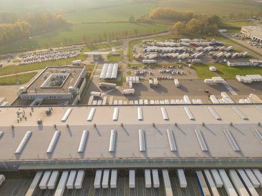 Malzeme deposunun havadan görüntüsü. Sanayi bölgesindeki lojistik merkezi yukarıdan. Lojistik merkezde yüklenen kamyonların hava görüntüsü. İnsansız hava aracından görüntüle.