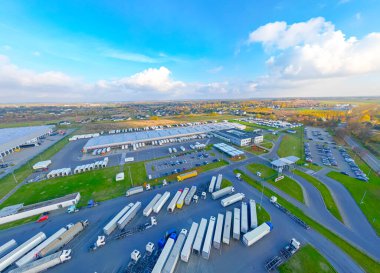 Malzeme deposunun havadan görüntüsü. Sanayi bölgesindeki lojistik merkezi yukarıdan. Lojistik merkezde yüklenen kamyonların hava görüntüsü. İnsansız hava aracından görüntüle.