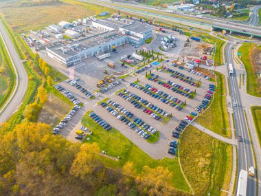 Gün batımında yükleme / boşaltma malları için rampalarda bekleyen depo, merkez ve kargo karavanıyla lojistik parkının hava görüntüsü.