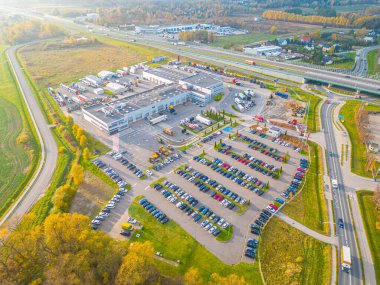 Gün batımında yükleme / boşaltma malları için rampalarda bekleyen depo, merkez ve kargo karavanıyla lojistik parkının hava görüntüsü.